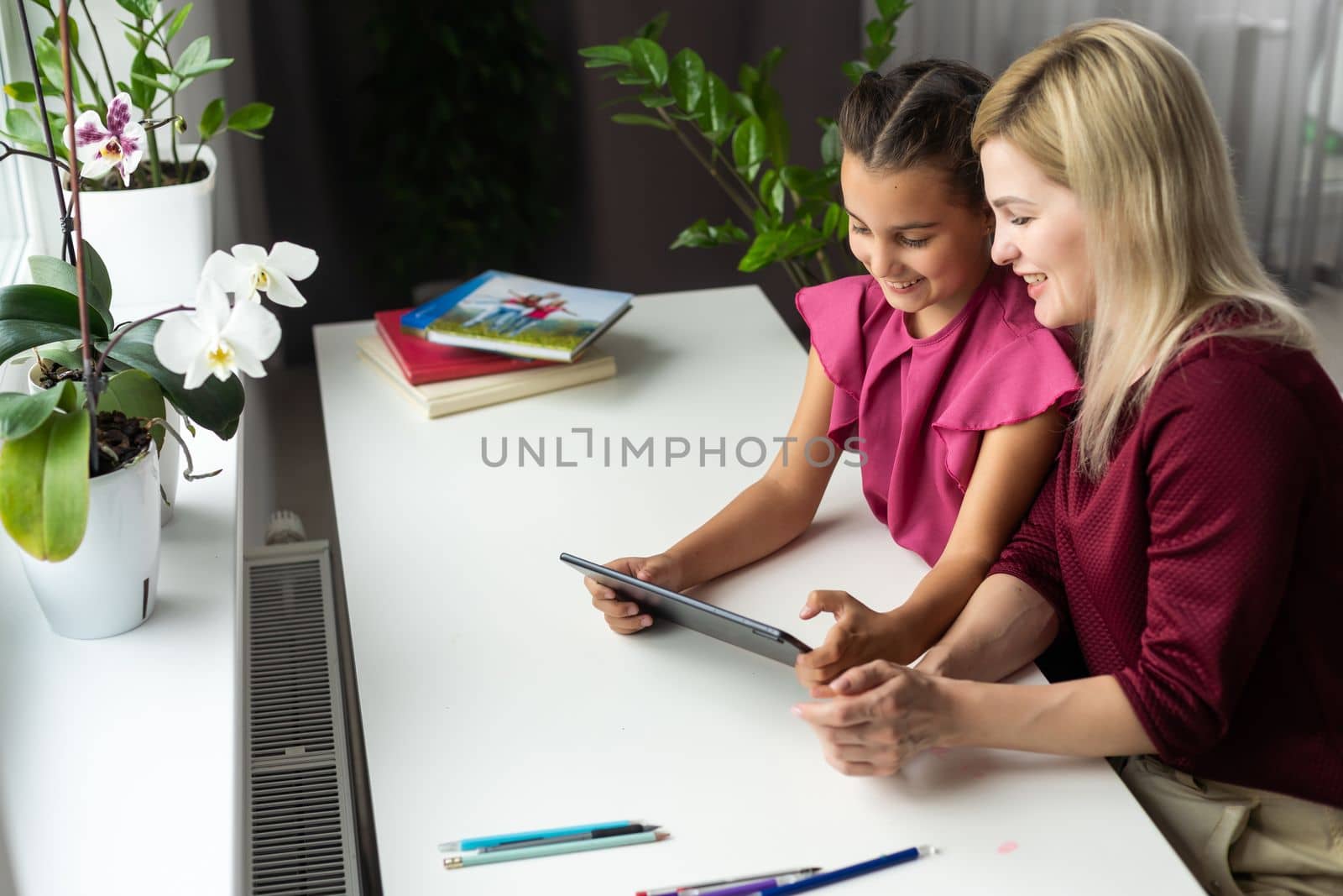 Mom with her tween daughter using tablet together