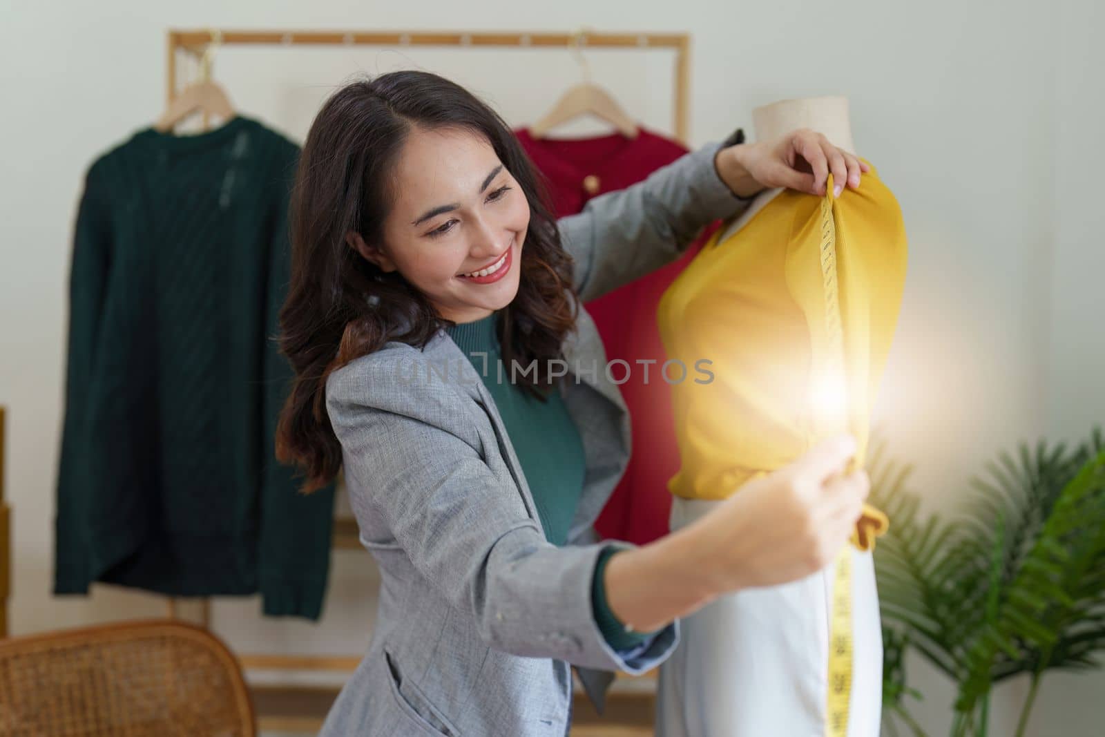 Asian Woman fashion designer cloth tailor creative working for new collection. Happy online store owner preparing an order for shipping by itchaznong