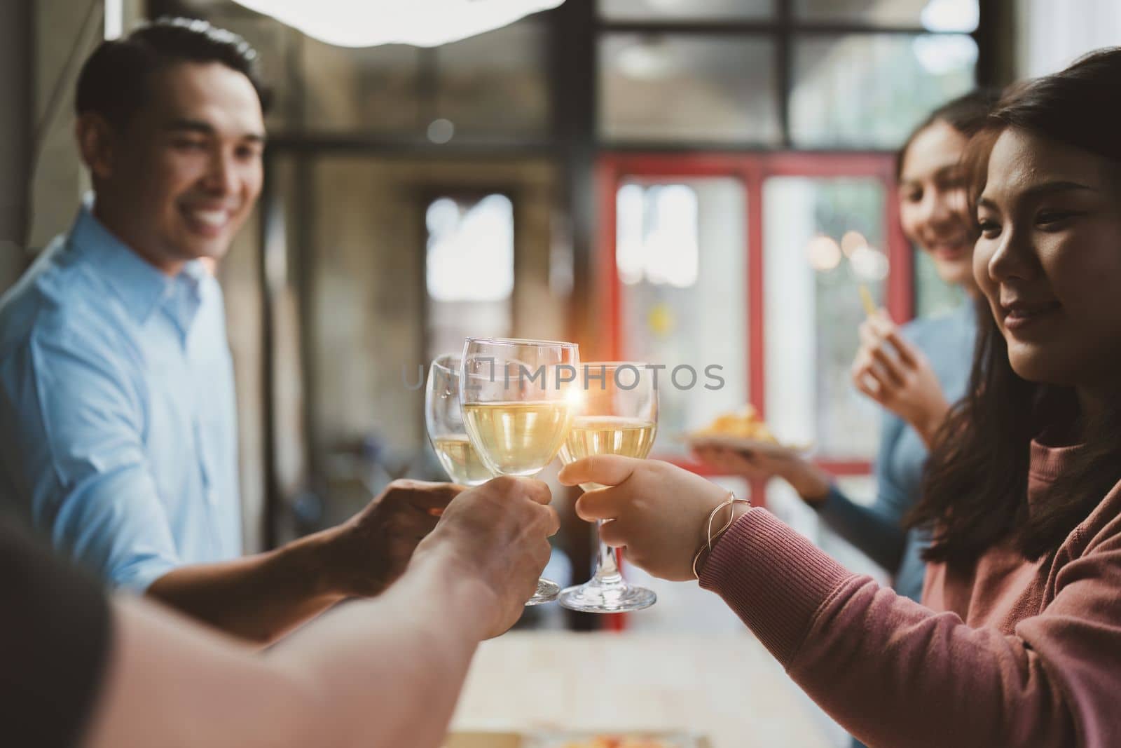 Friends at birthday party clinking glasses with champagne and pizza, enjoying Christmas vacation, pizza on the table. Holiday Party event
