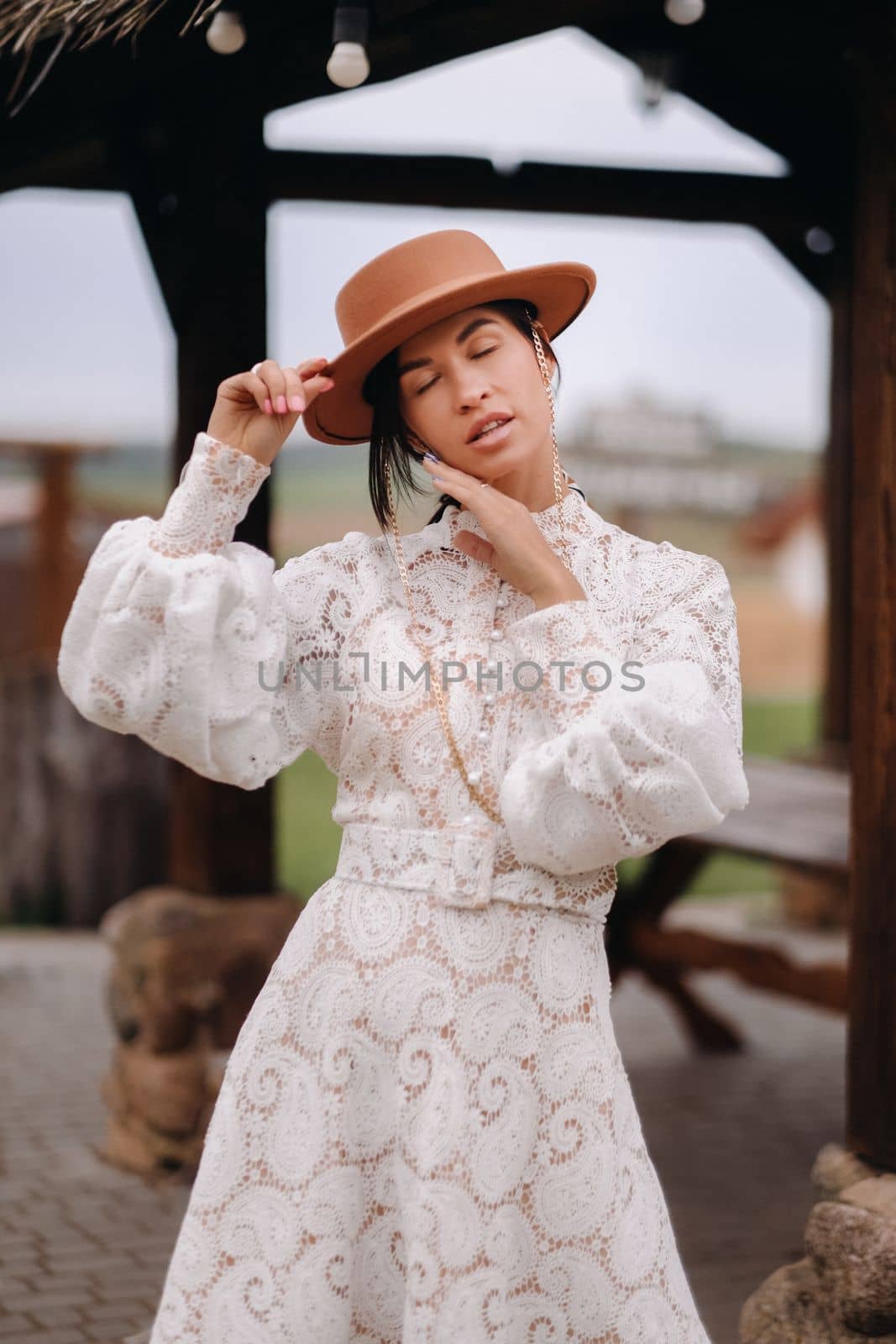 Beautiful girl in vintage lace dress and hat at the ranch.