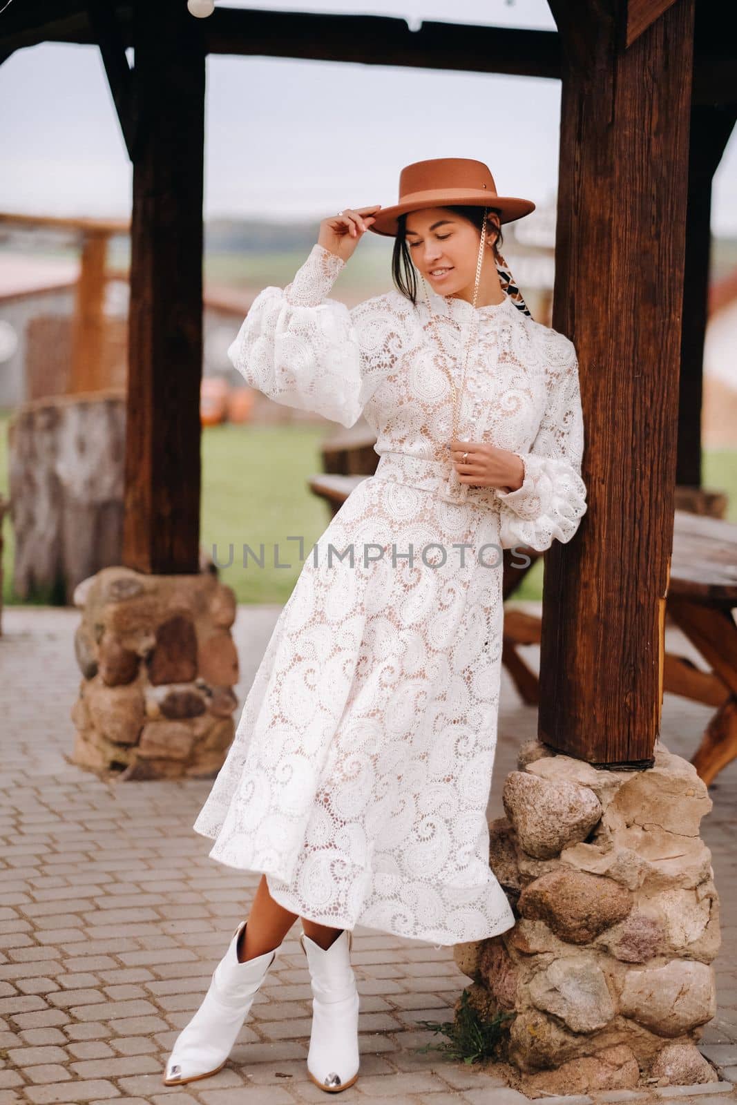 Beautiful girl in vintage lace dress and hat at the ranch.