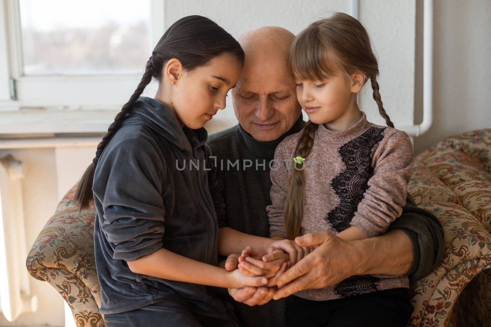 Hands of the old man and a child's hand