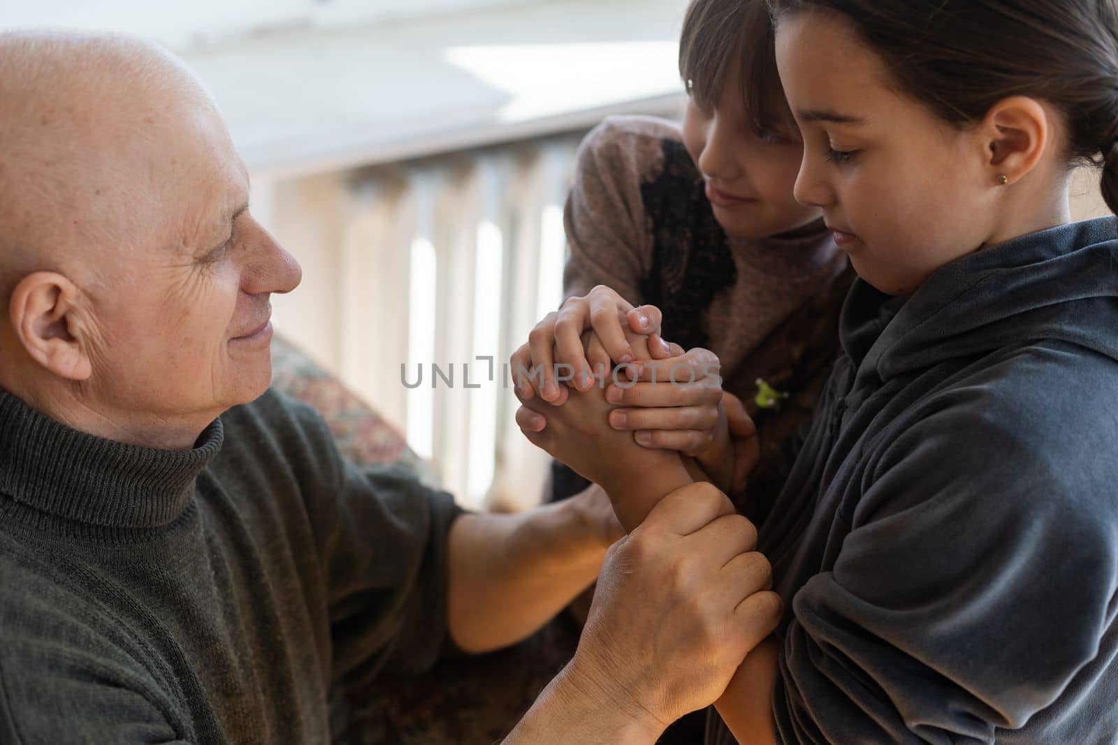 Hands of the old man and a child's hand