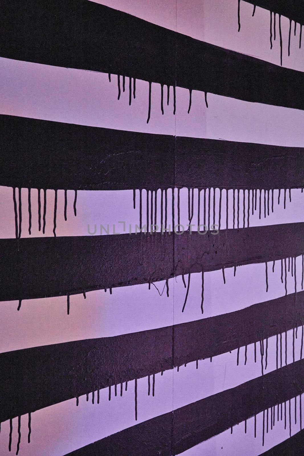 Image of Black and white stripes on wall with dripping black paint