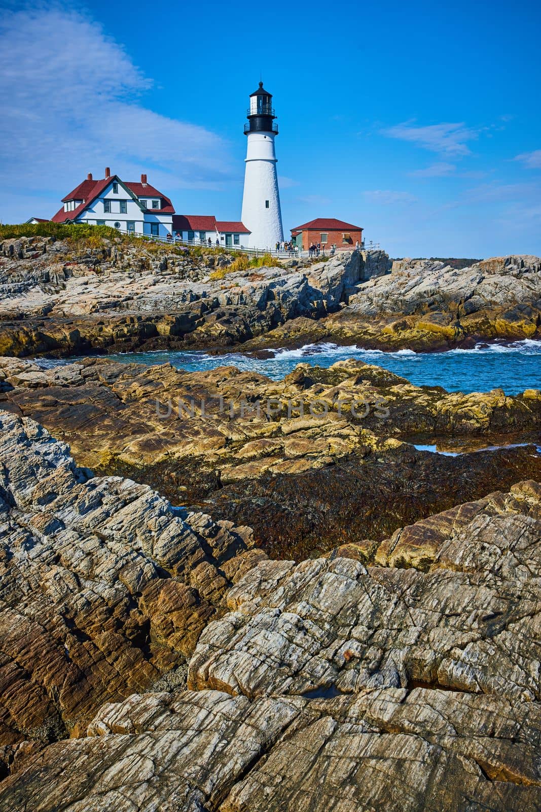 Image of Stunning Maine white lighthouse on ocean along rocky coastline