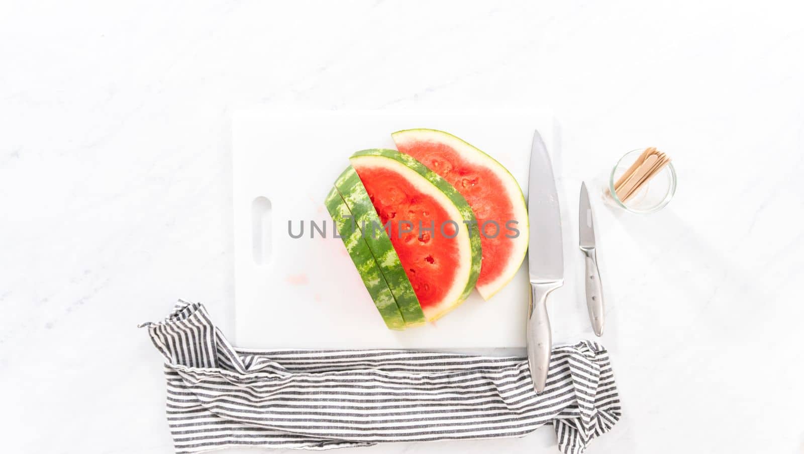 Flat lay. Slicing riped red watermelon to prepare chili lime watermelon pops.