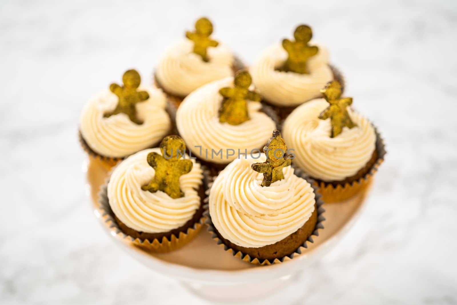 Freshly baked gingerbread cupcakes with eggnog buttercream frosting and topped with a gingerbread man.