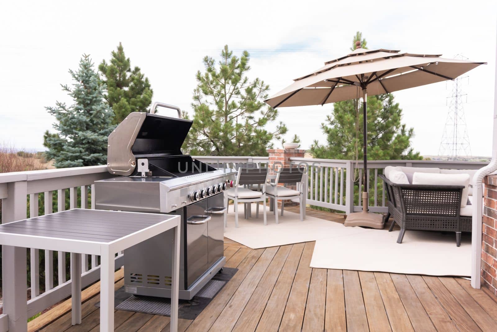 Outdoor six-burner gas grill on the back patio of a luxury single-family home.