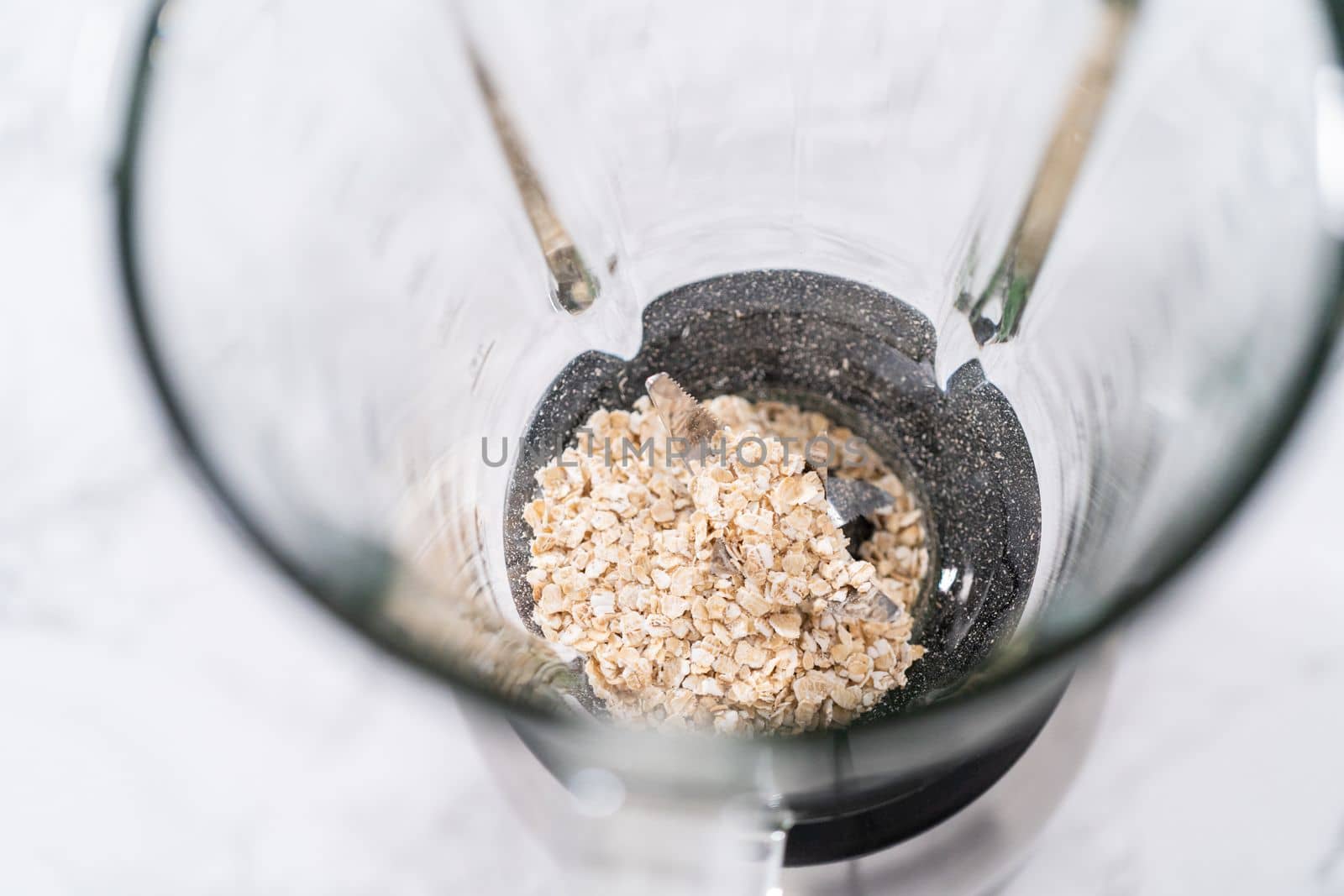 Blending ingredients for healthy breakfast strawberry banana smoothie in a kitchen blender.