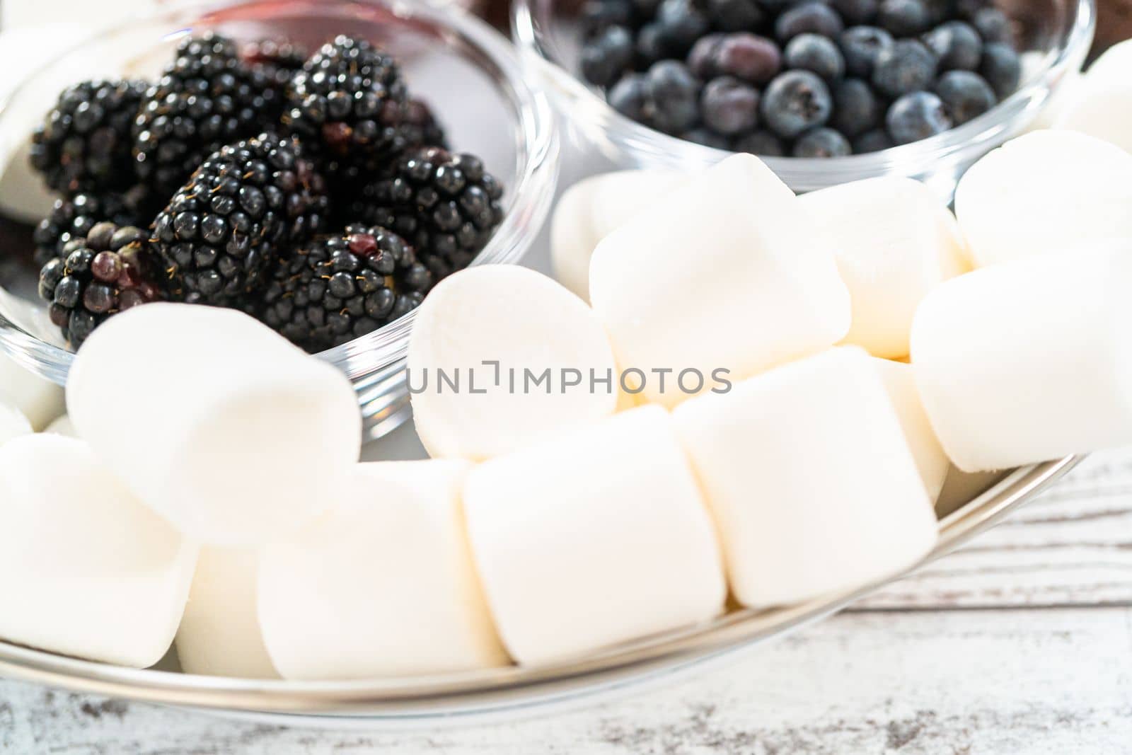 Arranging fruit s'mores charcuterie board on a white tray.