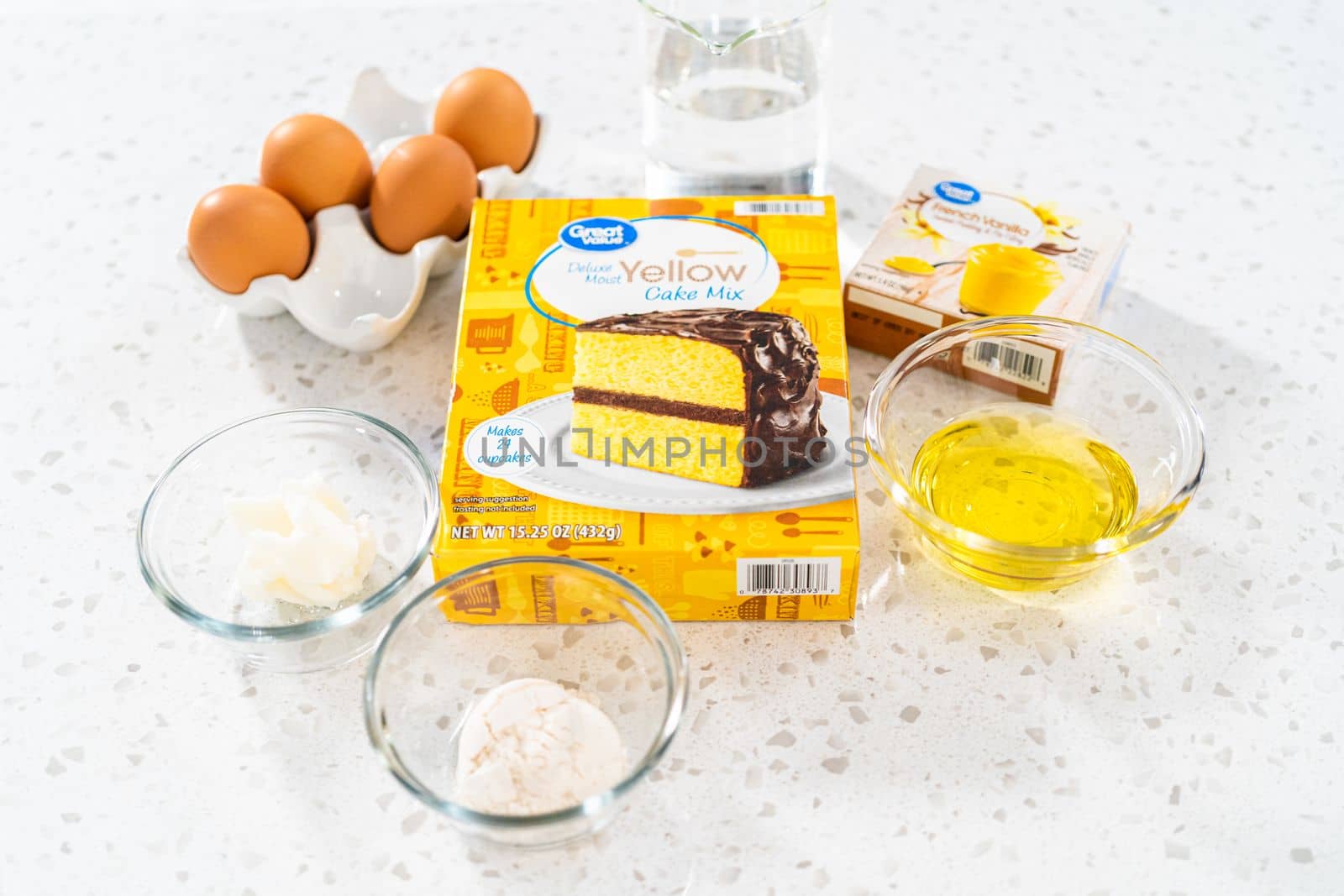 Measured ingredients in glass mixing bowls to bake a simple vanilla bundt cake from a box cake.