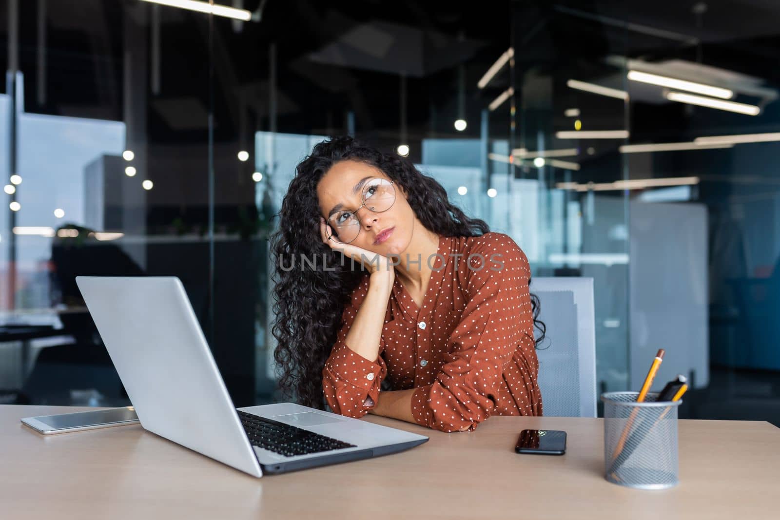 Boring work, hispanic woman working inside office, business woman working at desk using laptop at work.