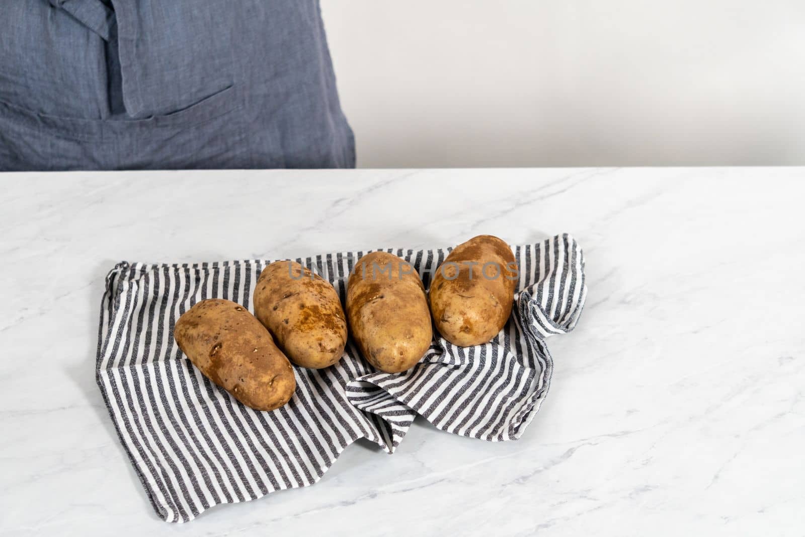 Pressure Cooker Baked Potatoes. Drying washed raw potatoes with a kitchen towel.