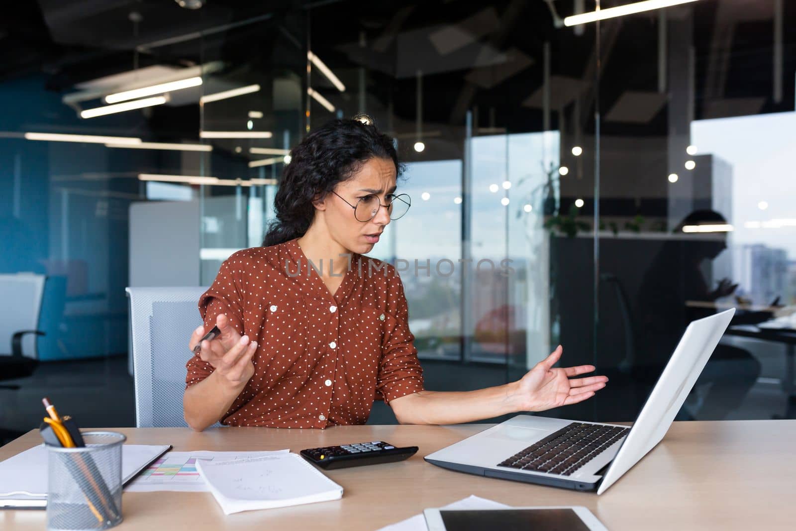 Businesswoman disappointed and sad at work, not happy with the result of achievement at work, Hispanic woman desperate and sad working inside office using laptop at work.