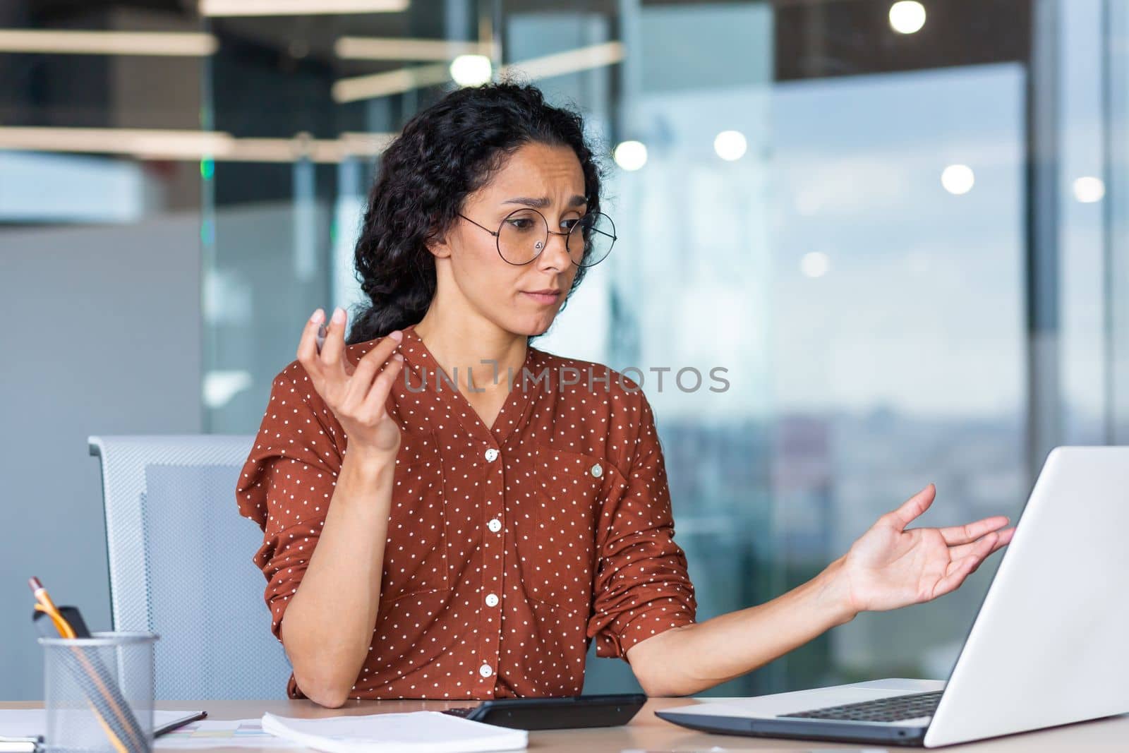 Businesswoman disappointed and sad at work, not happy with the result of achievement at work, Hispanic woman desperate and sad working inside office using laptop at work.