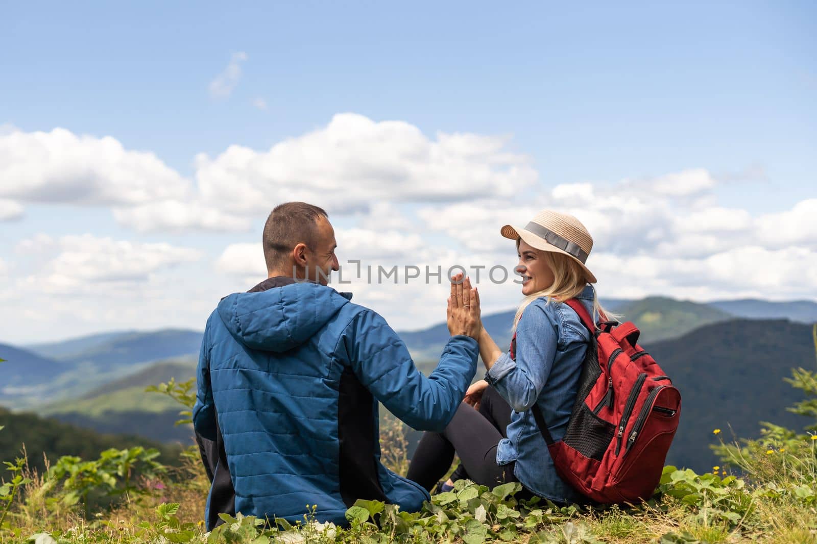 Portrait of beautiful young couple enjoying nature at mountain peak. by Andelov13