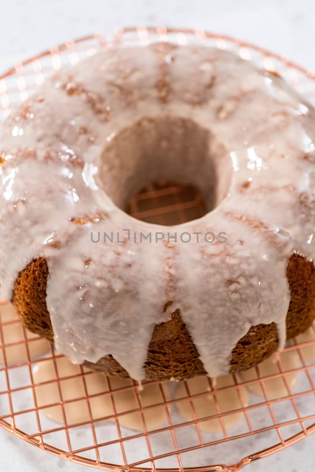 Glazing vanilla bundt cake with a white vanilla glaze.