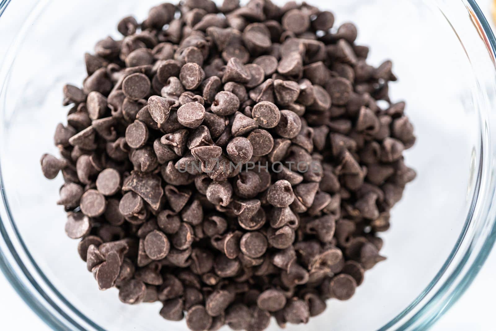 Measured ingredients in glass mixing bowls to prepare chocolate cupcake.