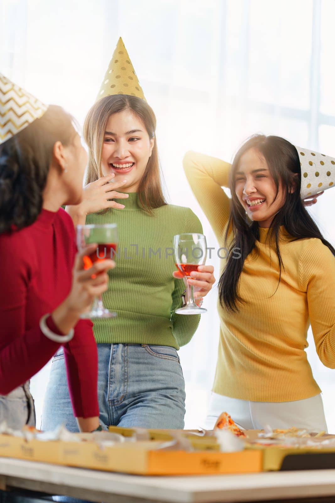 Friends at birthday party clinking glasses with champagne and pizza, enjoying christmas vacation, pizza on the table. Holiday Party event by itchaznong