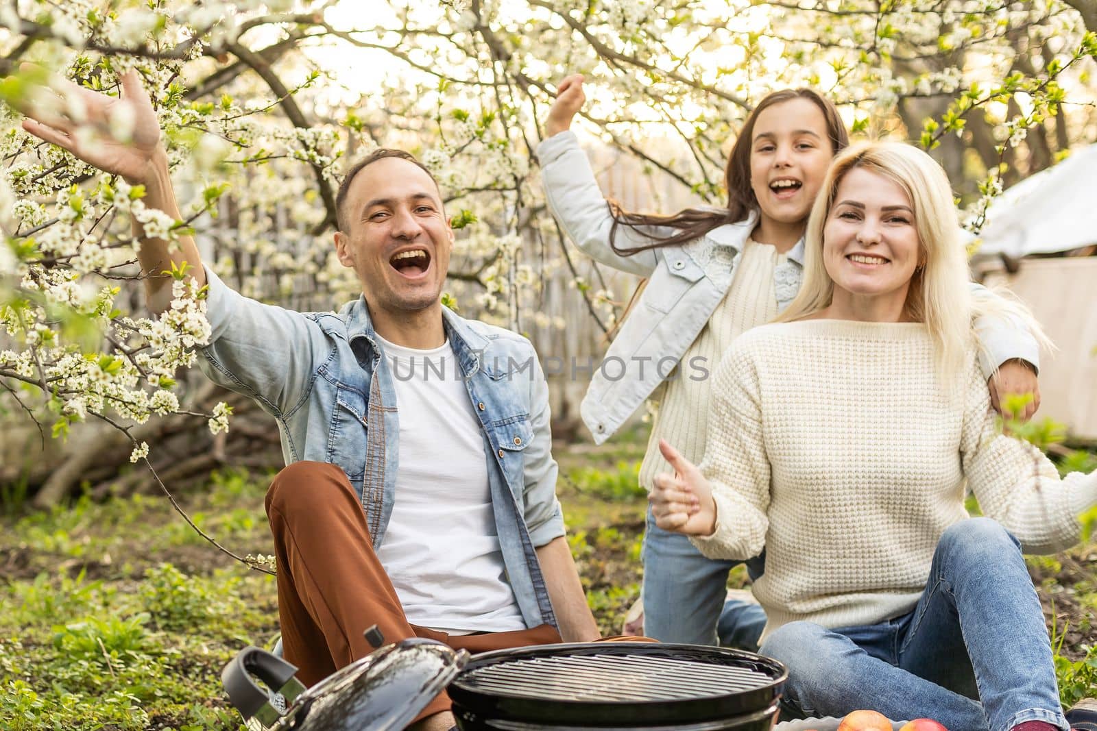 smiling parent grilling meat with daughter on camping by Andelov13