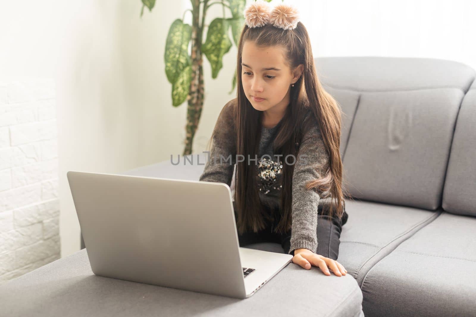 E-education, online lessons and courses for schoolers. Joyful teen girl looking at laptop screen, watching online lesson or listening to tutor, home interior, copy space by Andelov13