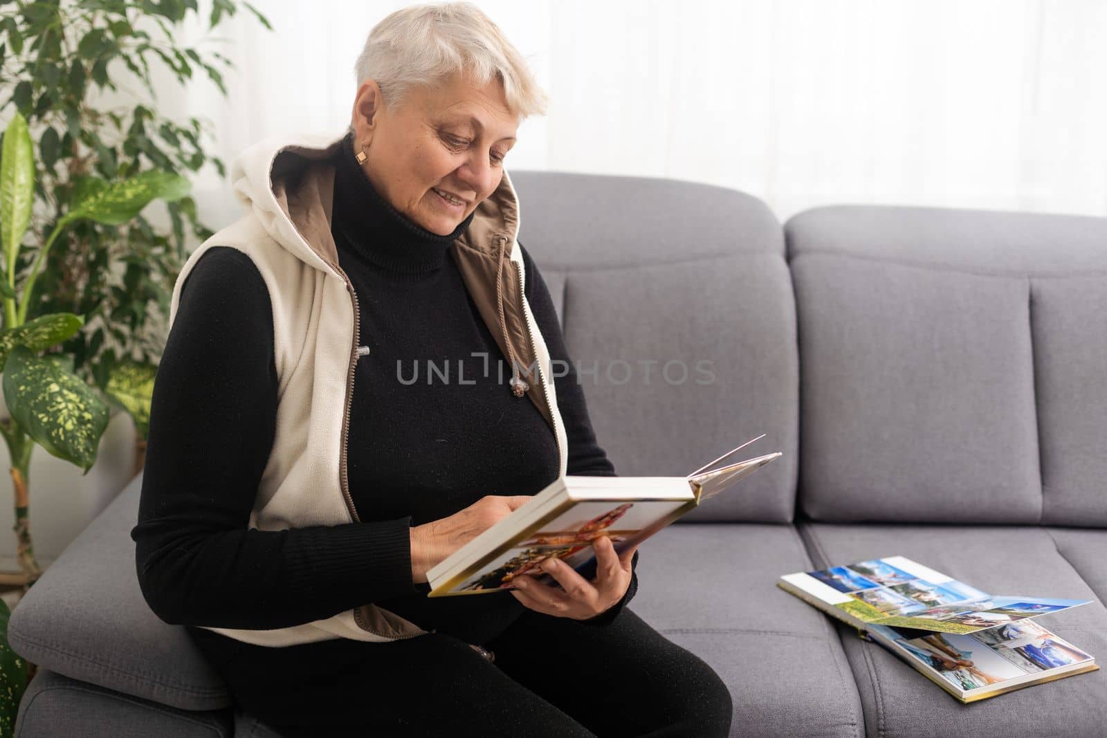 senior woman holding a family photo album, photo book.