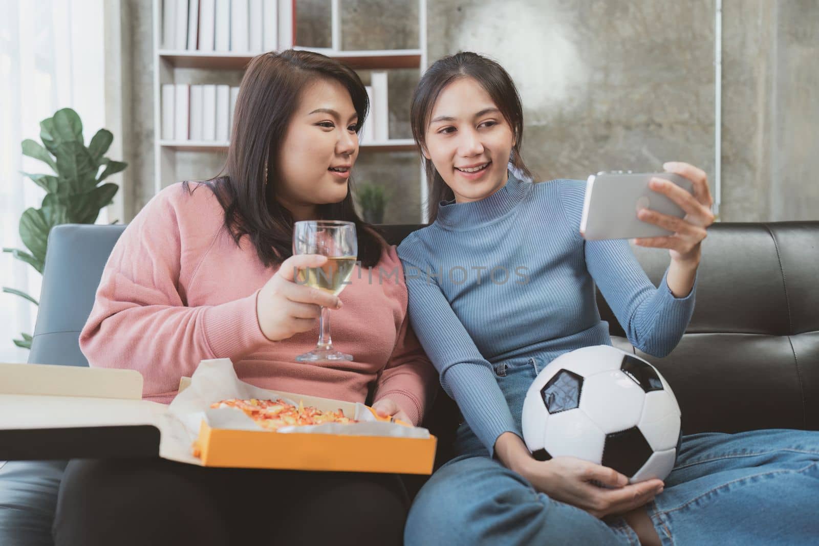 Excited friends having fun by watching football or soccer match and eating pizza at home. Friendship, leisure, rest, home party football, Soccer concept by itchaznong