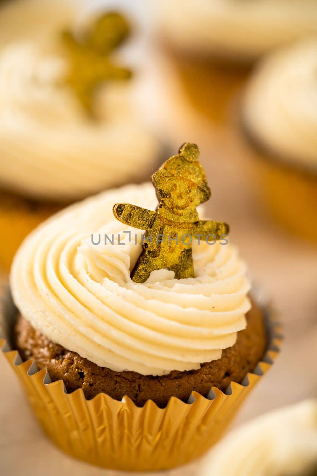 Freshly baked gingerbread cupcakes with eggnog buttercream frosting and topped with a gingerbread man.