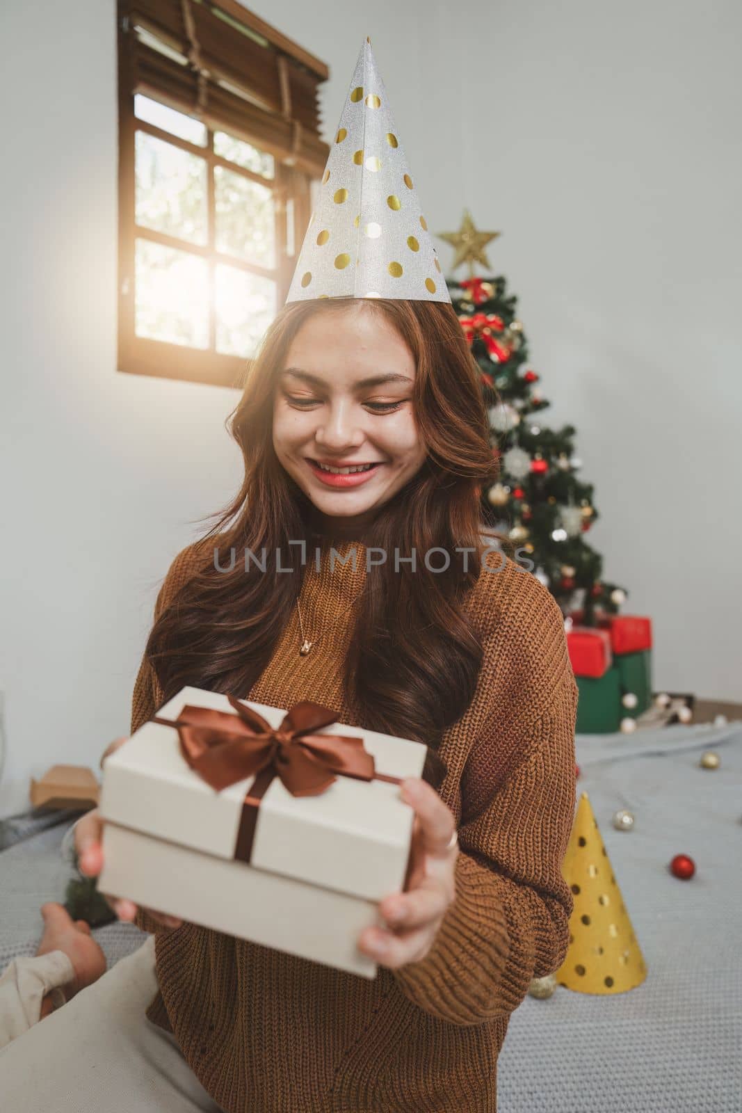 Cheerful lady surprised of the present after the opening in the gift box. Marry Christmas and Happy Holidays and New Year eve celebrating concept.