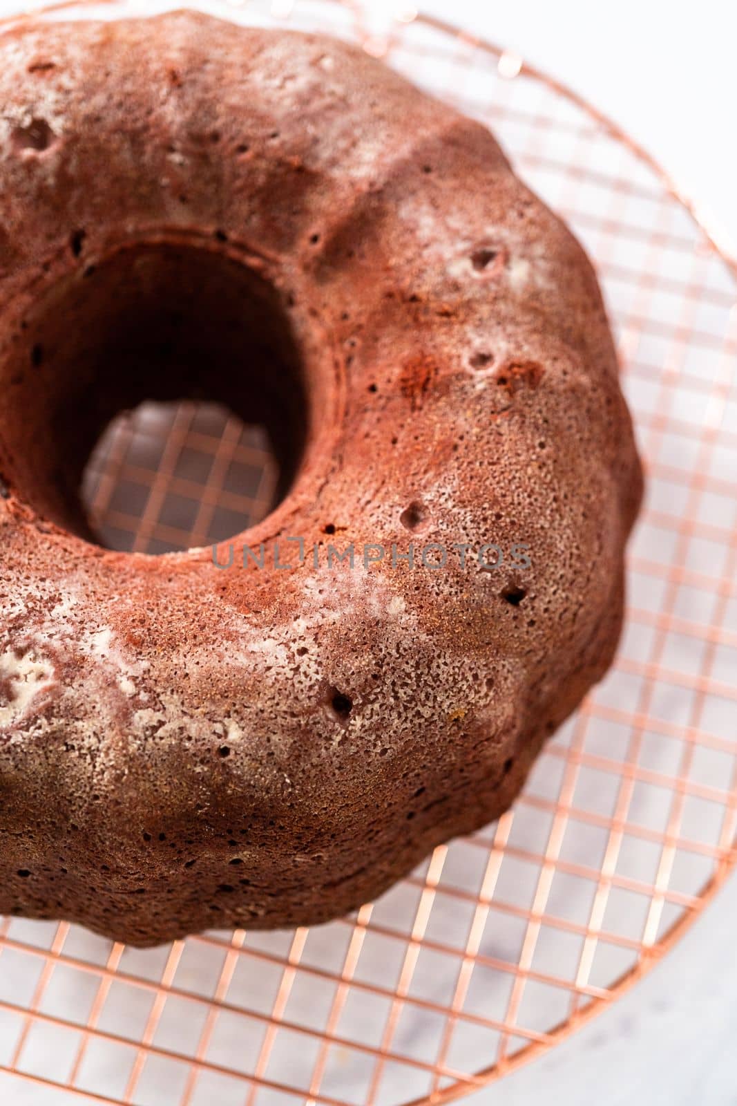 Cooling freshly baked red velvet bundt cake on a kitchen counter.