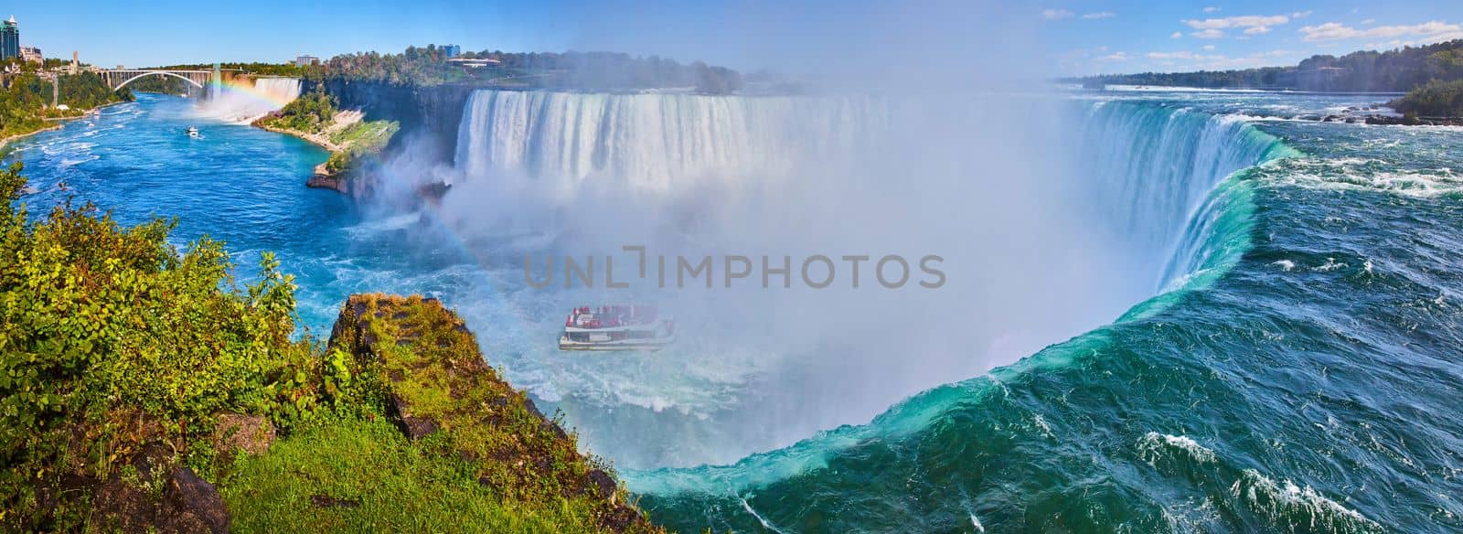 Image of Wide panorama on edge of Horseshoe Falls showcasing size and misty falls with tourist ship