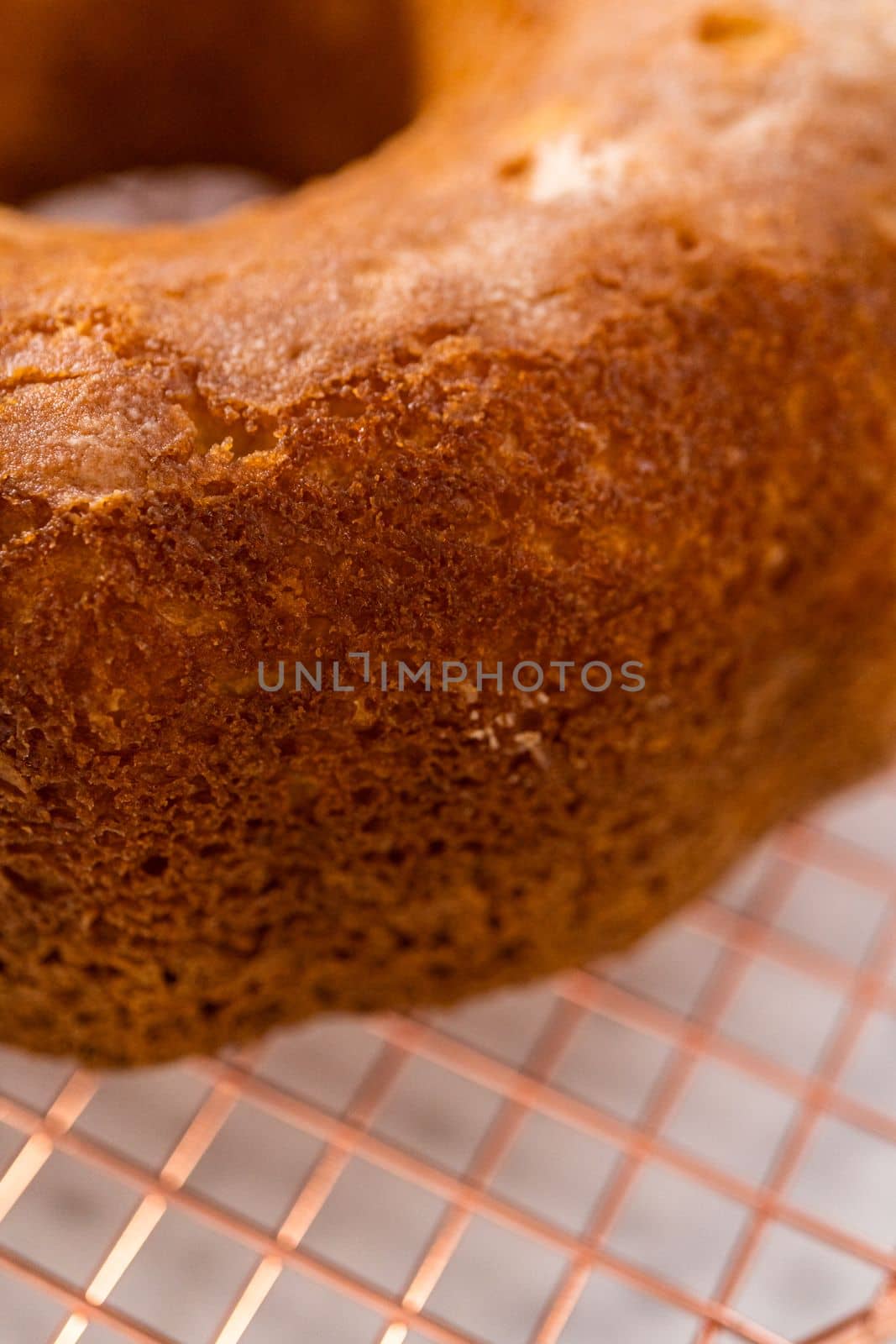 Cooling freshly baked simple vanilla bundt cake on a kitchen counter.