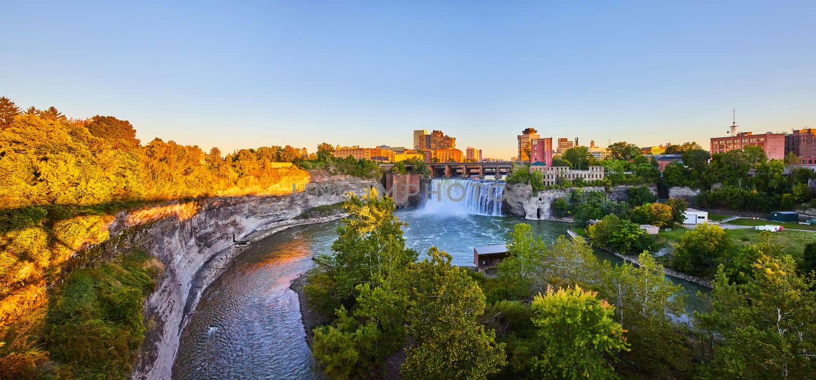 Image of Stunning waterfall at golden hour in city of Rochester New York with downtown in background