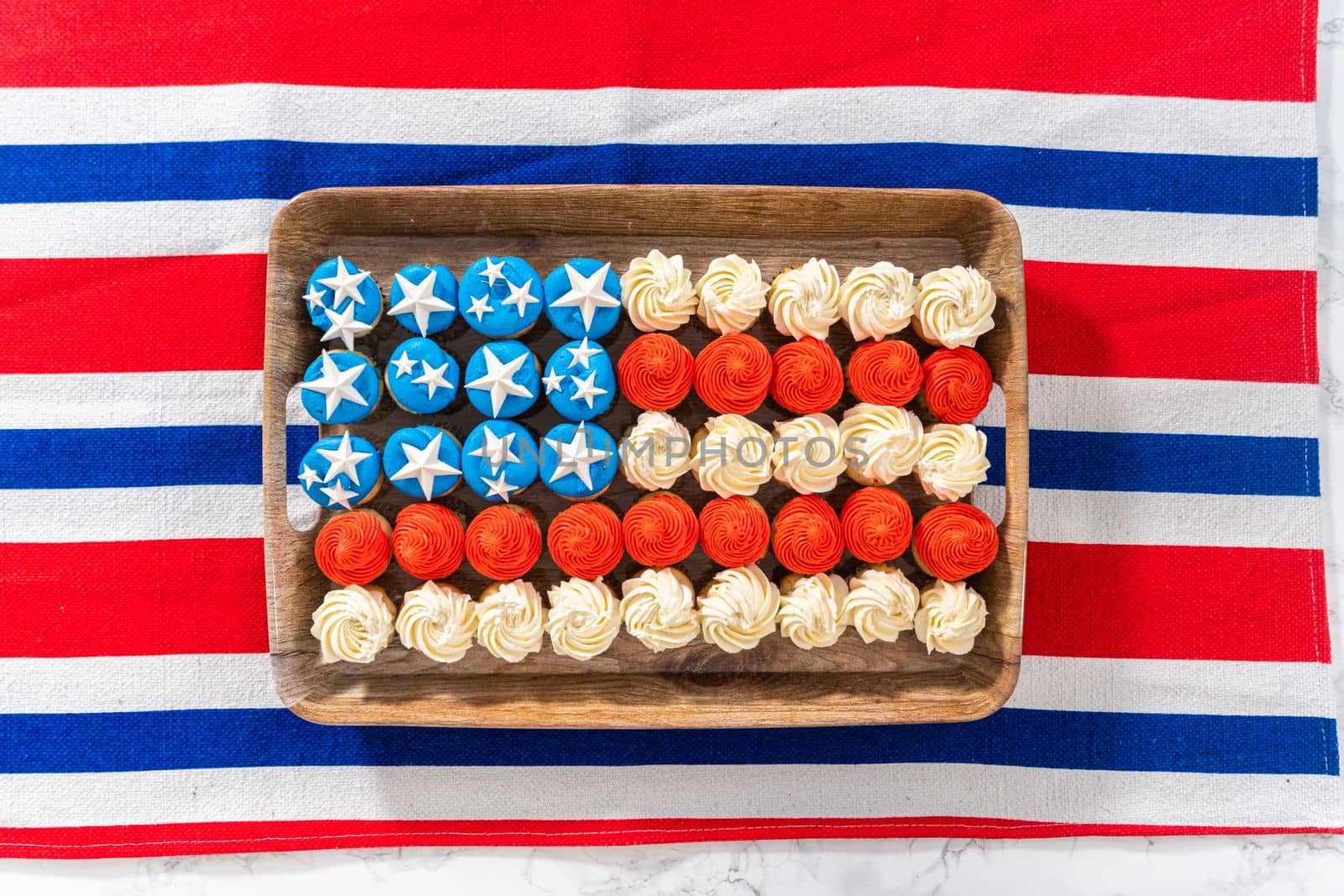 Flat lay. Arranging mini vanilla cupcakes in the shape of the American flag.