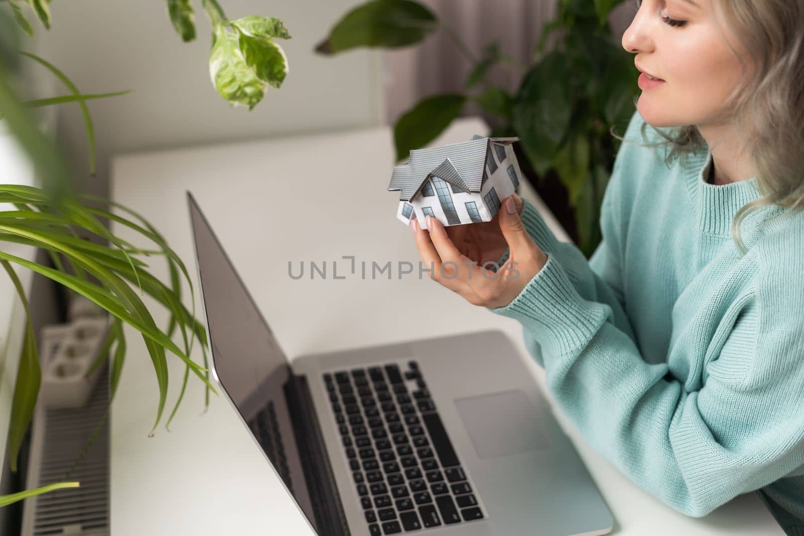 Hands of young woman holding model house, real estate insurance and banking concept