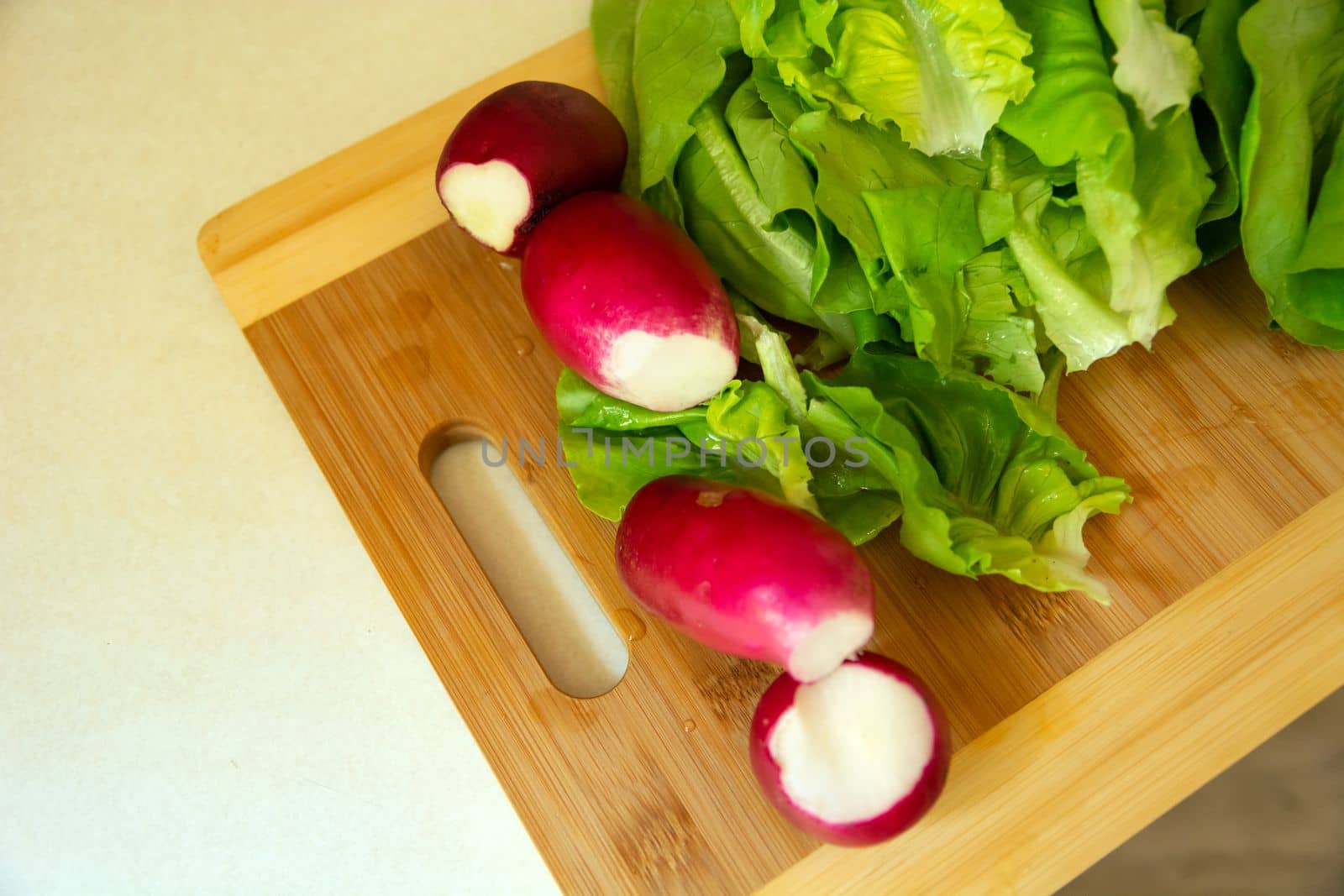 Fresh radish and lettuce on a chopping board, top view