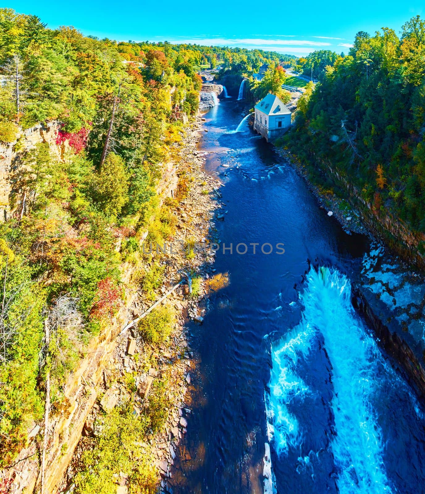Image of Aerial over stunning canyon with Hydroelectric power plant and multiple large waterfalls over cliffs