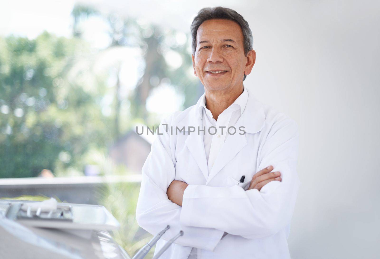 Friendly face of your family dentist. Portrait of a mature male surgeon standing in the hospital. by YuriArcurs