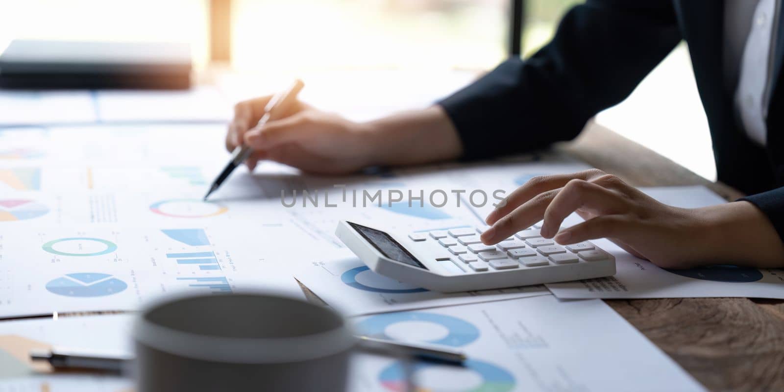 Accountant woman working on calculator to calculate business data finance. tax, accounting, financial concept.