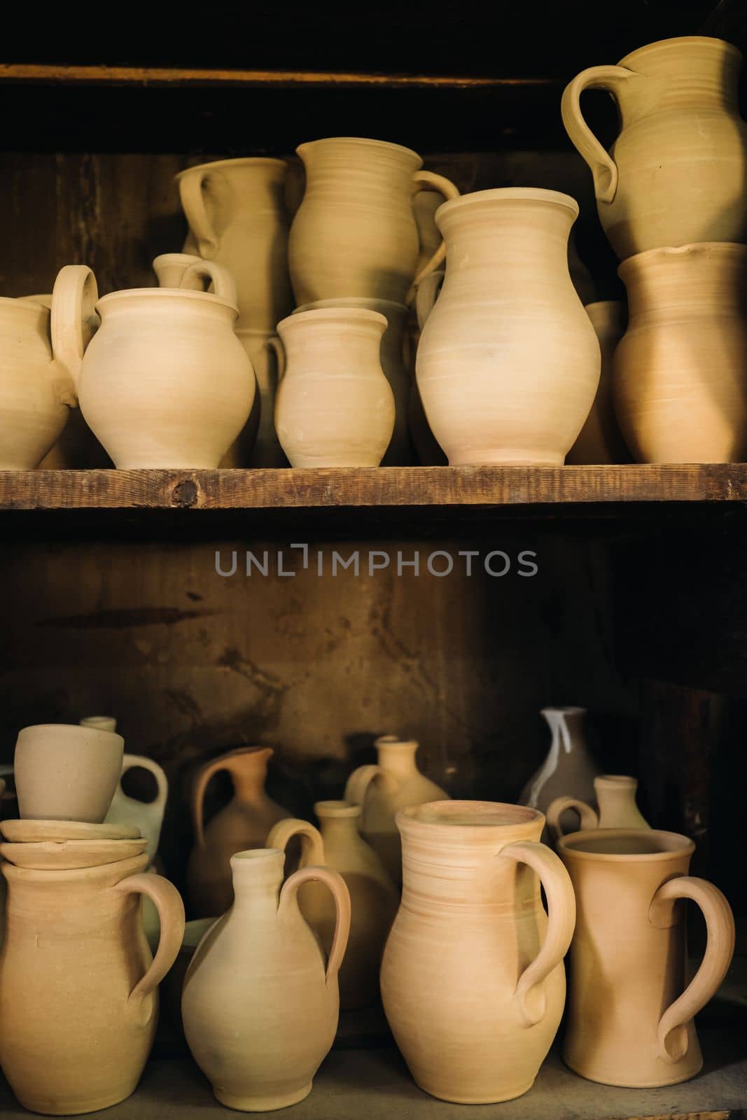 Ceramic clay jugs standing on a shelf in the village.