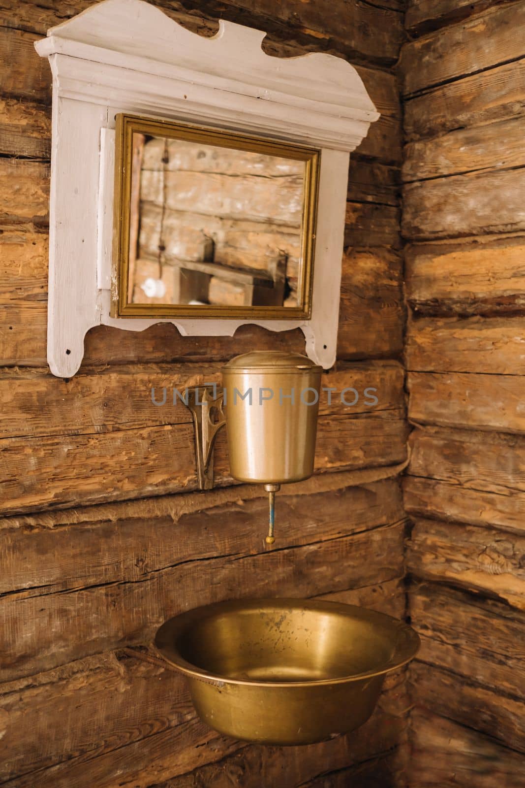 Vintage shot of an old metal washbasin and mirror in a wooden house in the village.