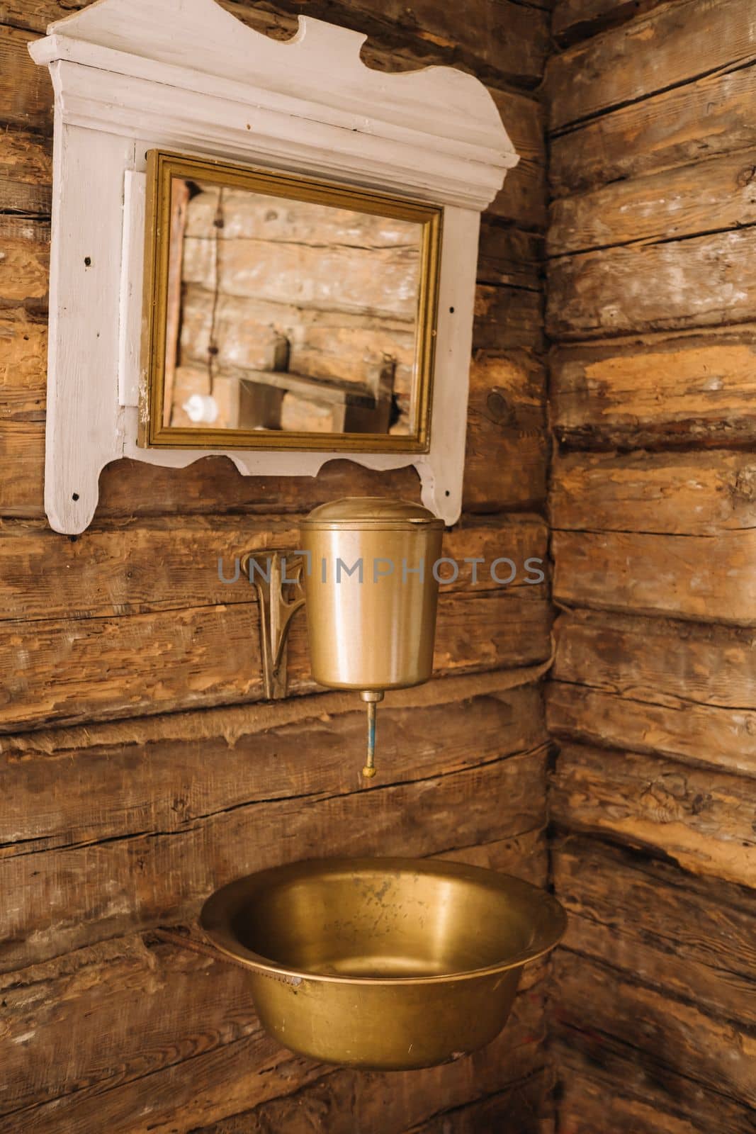 Vintage shot of an old metal washbasin and mirror in a wooden house in the village.