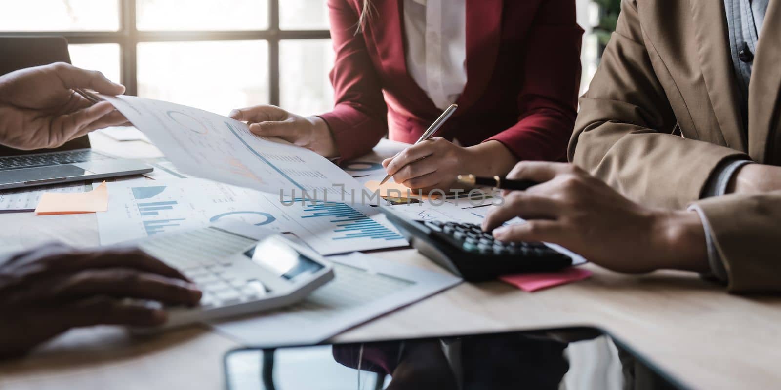 Business People Meeting using laptop computer,calculator,notebook,stock market chart paper for analysis Plans to improve quality next month. Conference Discussion Corporate Concept.