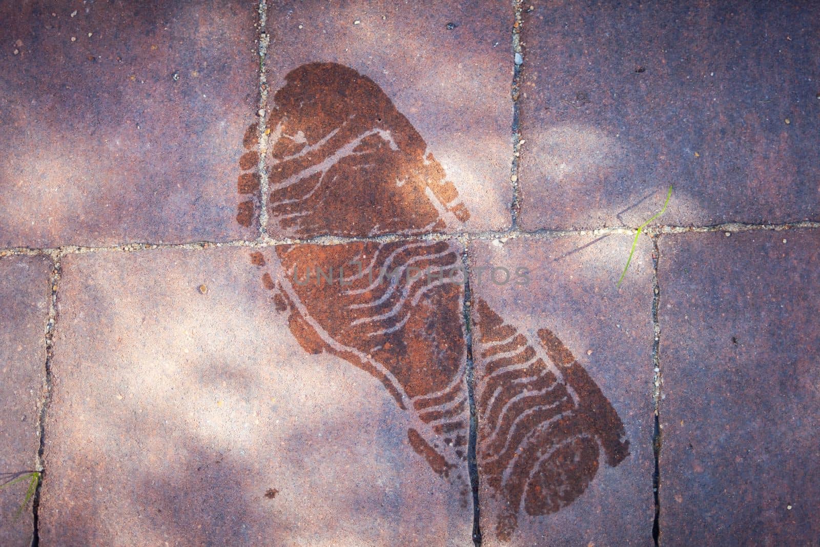 Wet shoe sole mark on the sidewalk, top view