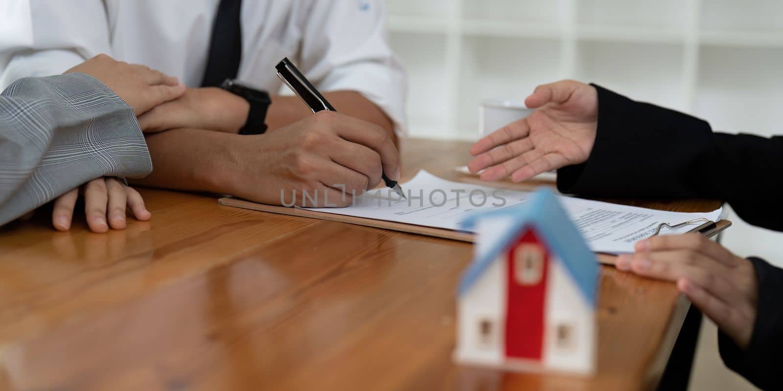 Young couple signing contract agreement with real estate agent