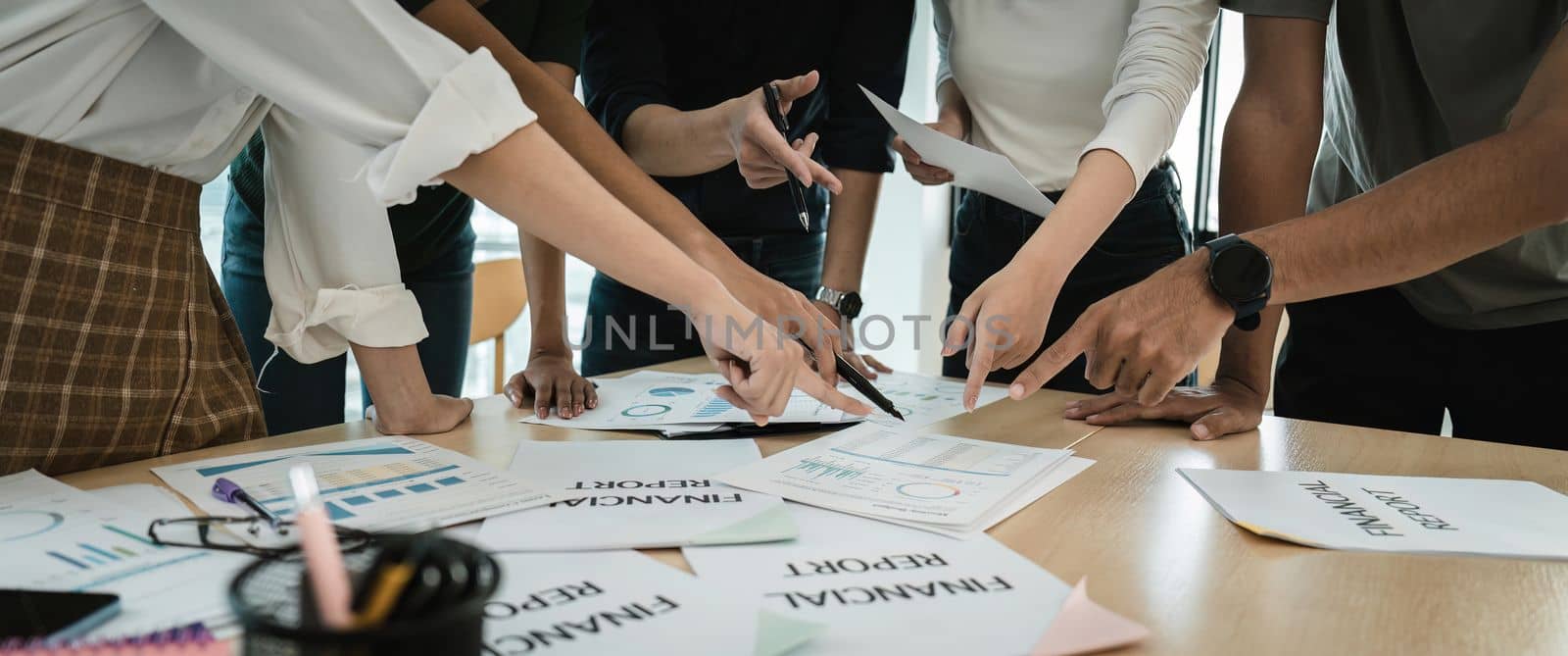 Crop shot of team group of creative young people discussing business startup project at meeting table during brainstorming in modern office.