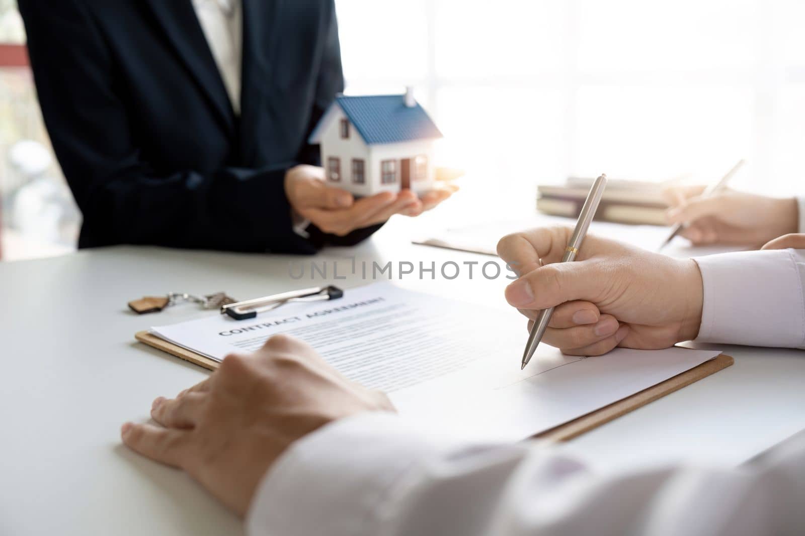 Real estate agent with couple closing a deal and signing a contract. by nateemee