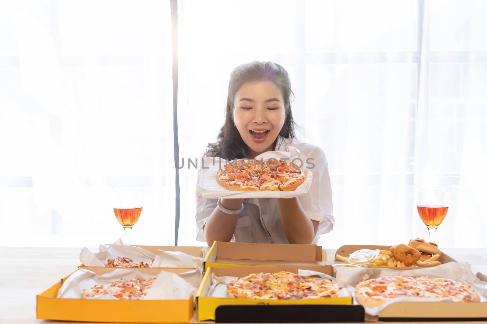 Portrait of Asian celebrate Christmas with champagne and eating pizza at home. Joy of holiday party with friends or colleague concept.
