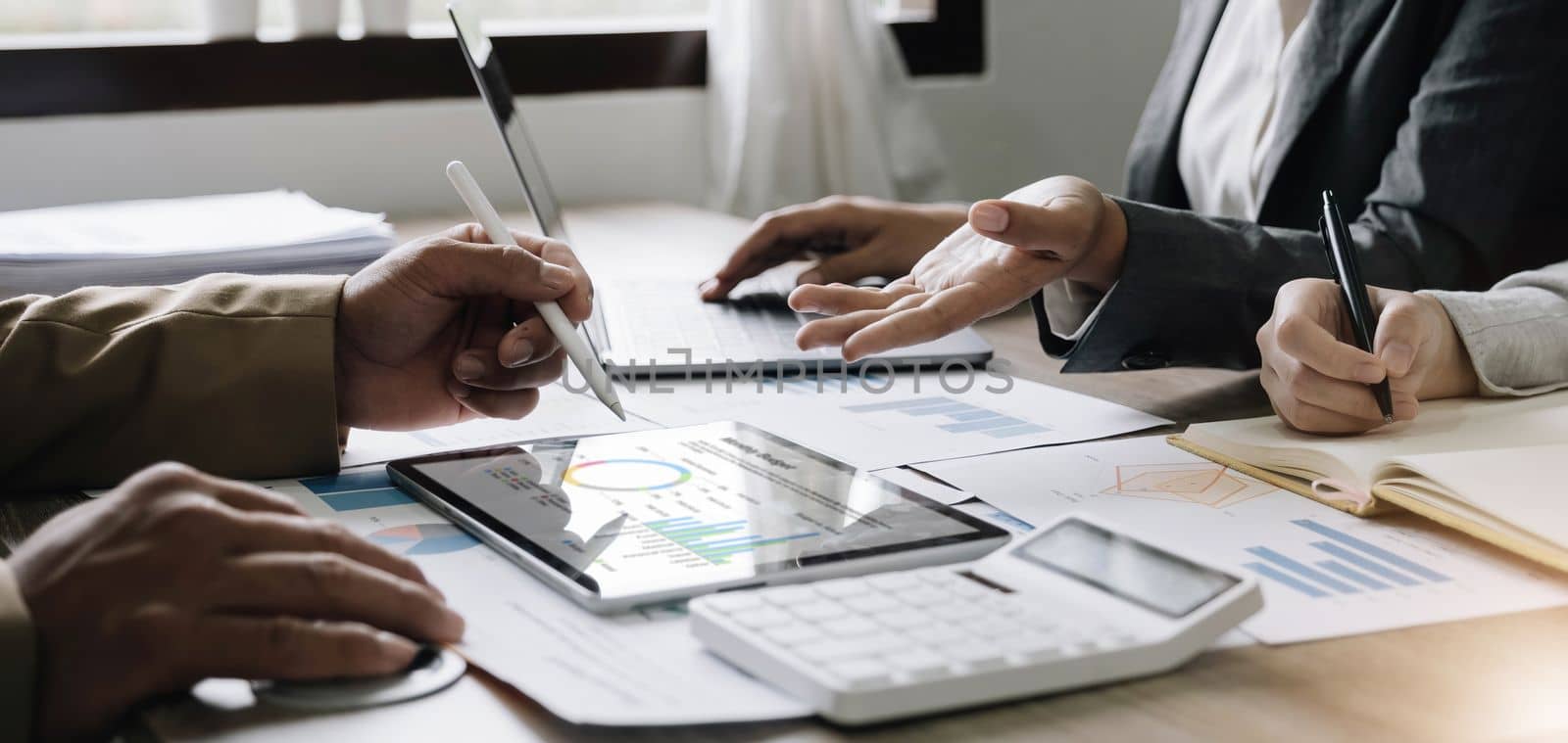 Business People Meeting using laptop computer,calculator,notebook,stock market chart paper for analysis Plans to improve quality next month. Conference Discussion Corporate Concept.