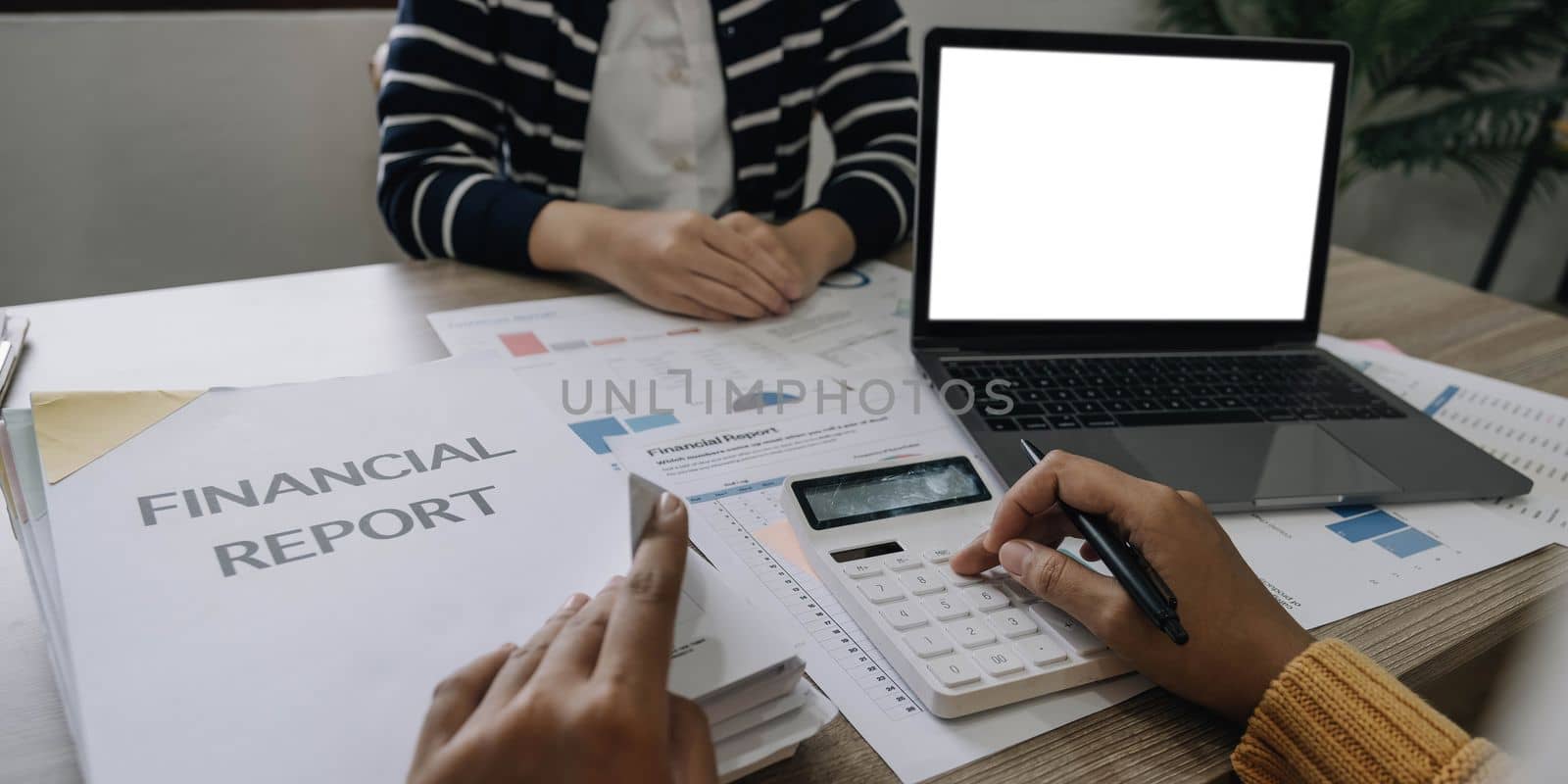 Businesswoman holding pens and holding graph paper are meeting to plan sales to meet targets set in next year... by wichayada